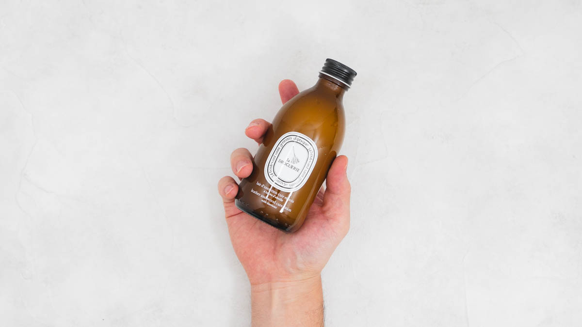 DIPTYQUE(ディプティック)レザー&ウッド ケアローションを手に持つ